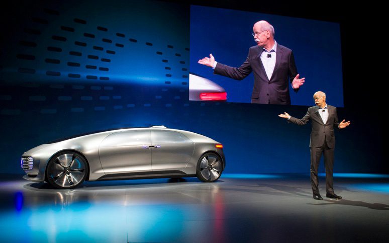Dieter Zetsche, chief executive officer of Daimler AG, gestures as he speaks about the Mercedes-Benz F015 concept vehicle at a news conference during the 2015 Consumer Electronics Show (CES) in Las Vegas, Nevada, U.S., on Monday, Jan. 5, 2015. Mercedes-Benz aims to transform the car into a rolling luxury lounge that chauffeurs passengers autonomously. Photographer: David Paul Morris/Bloomberg via Getty Images