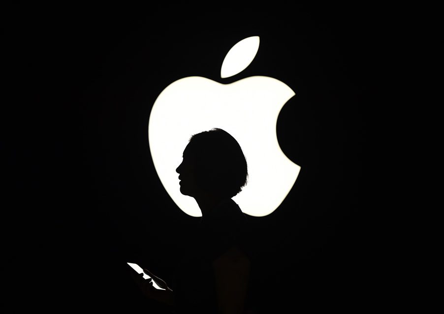 (FILES) In this file photo a reporter walks by an Apple logo during a media event in San Francisco, California on September 9, 2015.  - Apple on August 19, 2020 became the first US company to reach $2 trillion in market value in the latest demonstration of how tech giants have benefited amid the upheaval of the coronavirus. The iPhone maker attained the distinction in mid-morning trading and was up 1.3 percent at $468.34 near 1500 GMT. In March 2018, Apple became the first giant to hit $1 trillion in market value. (Photo by Josh Edelson / AFP)